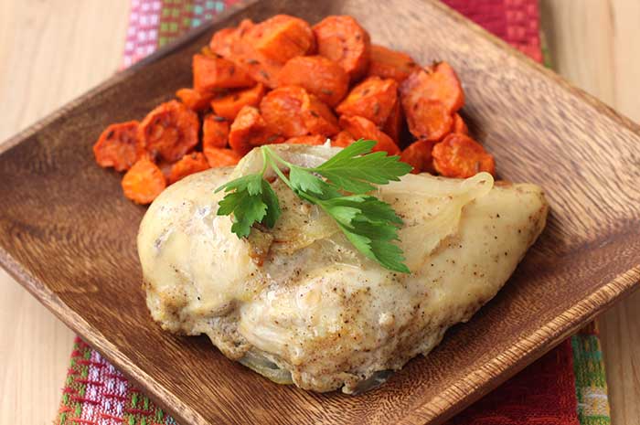 Quick and Easy Chicken Masala on a wooden plate with cooked carrots