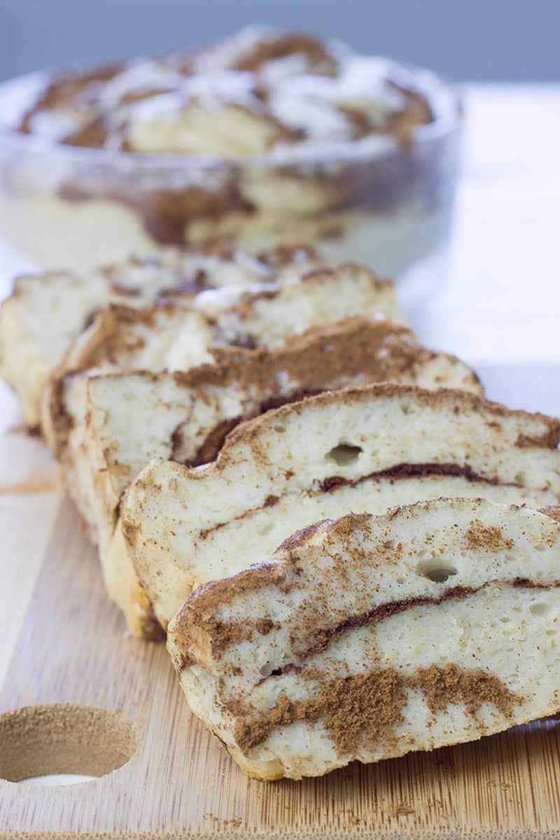 Sliced cinnamon swirl cake on a wooden cutting board