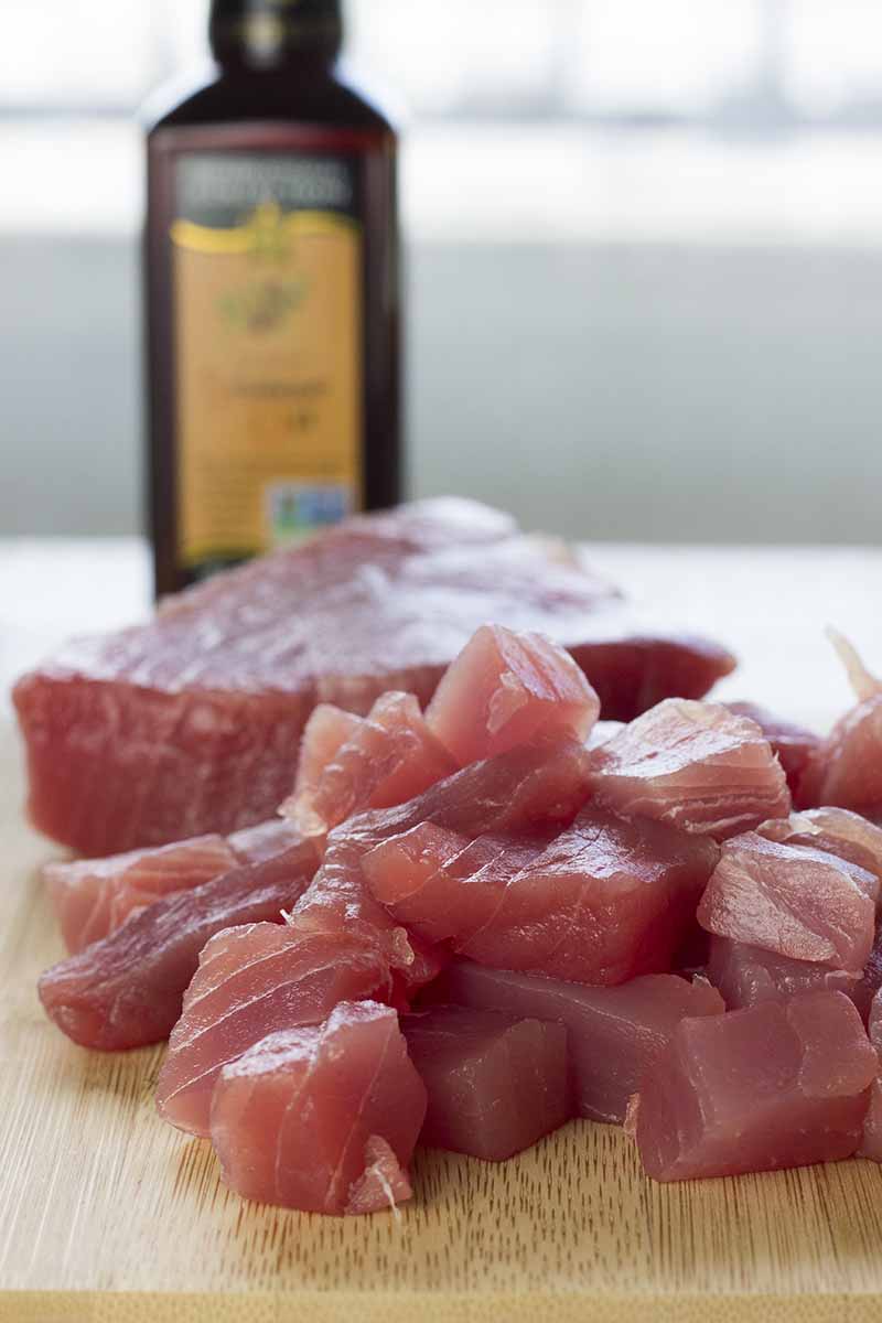 Raw ahi tuna cut into cubes on a cutting board