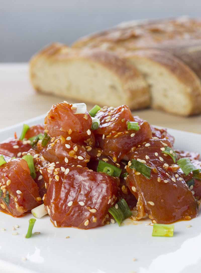 Freshly made ahi tuna poke on a plate with bread