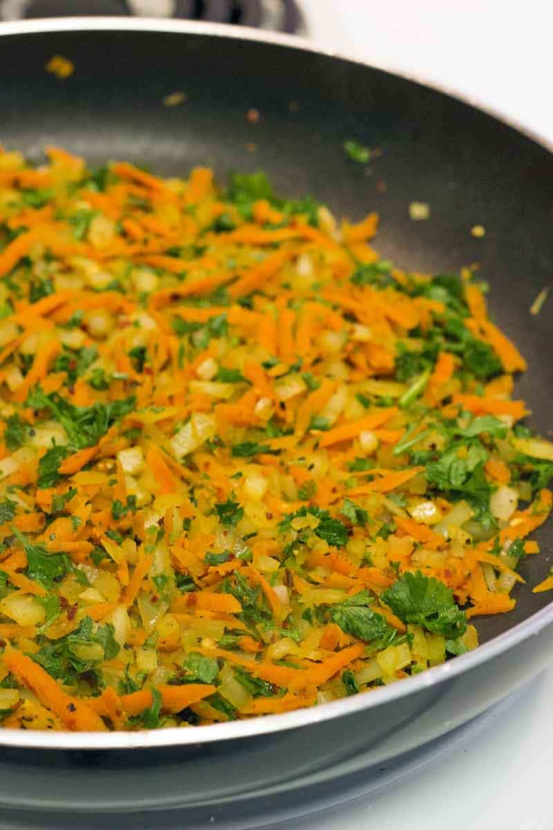 Shredded vegetables frying in a pan