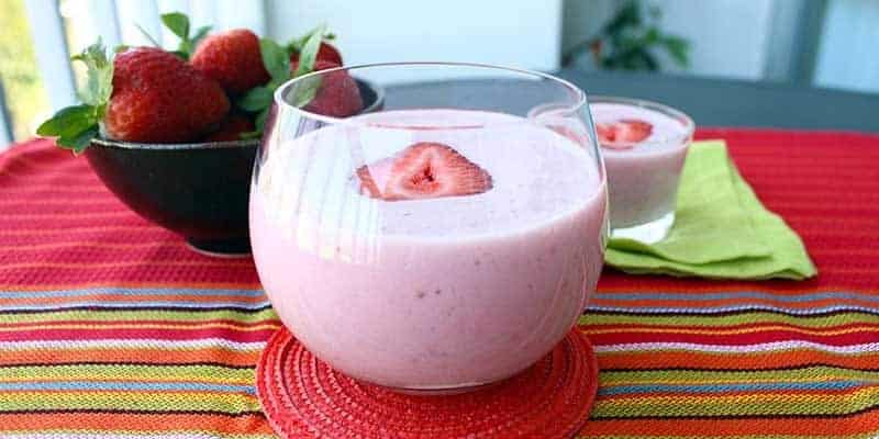 Blended smoothie in a glass with a slice of strawberry on top