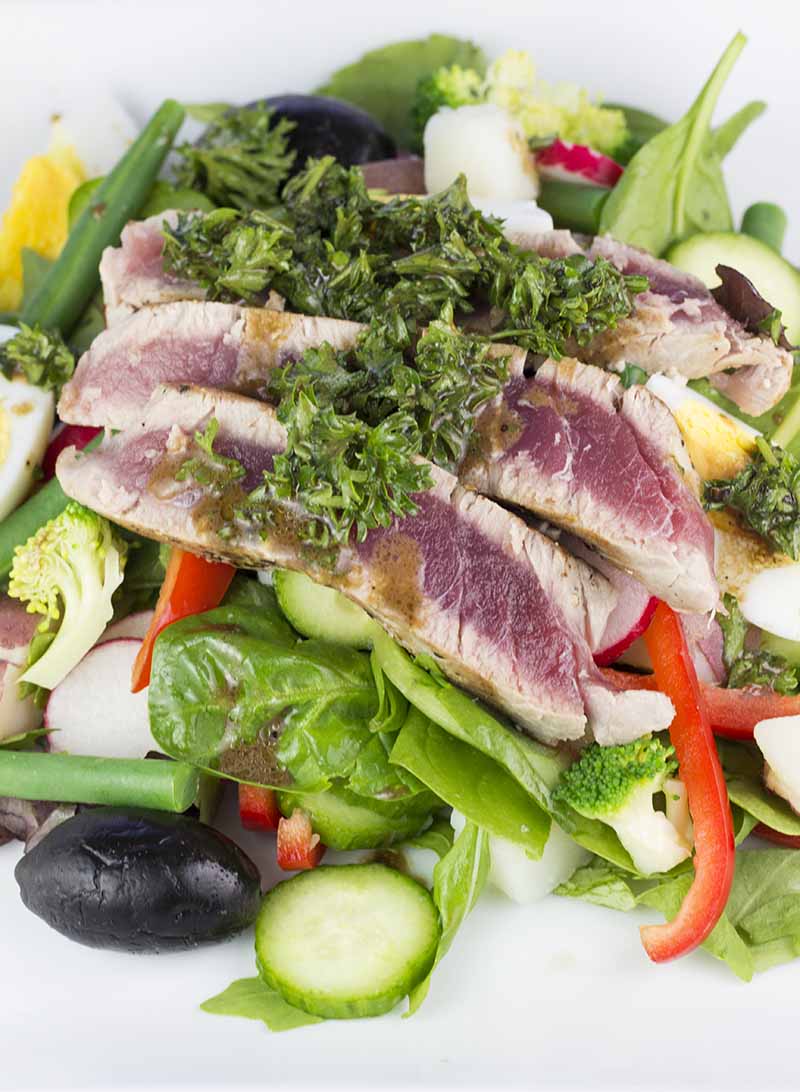 Seared tuna over salad and topped with parsley mustard dressing, as seen from above