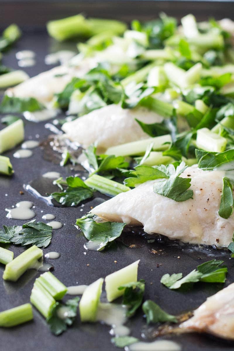 Snapper Fillet With Celery Parsley Salad on black oven pan