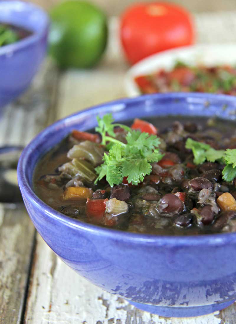 Vegan black bean soup in a blue bowl with cilantro on top