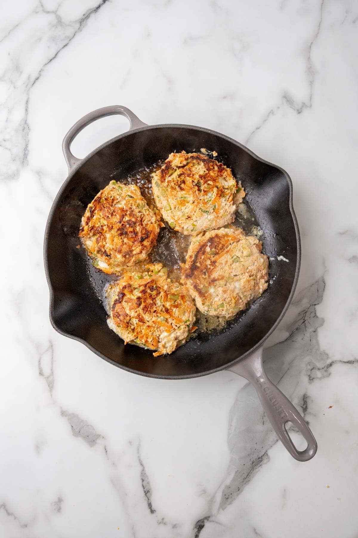 Fully cooked burgers in a pan