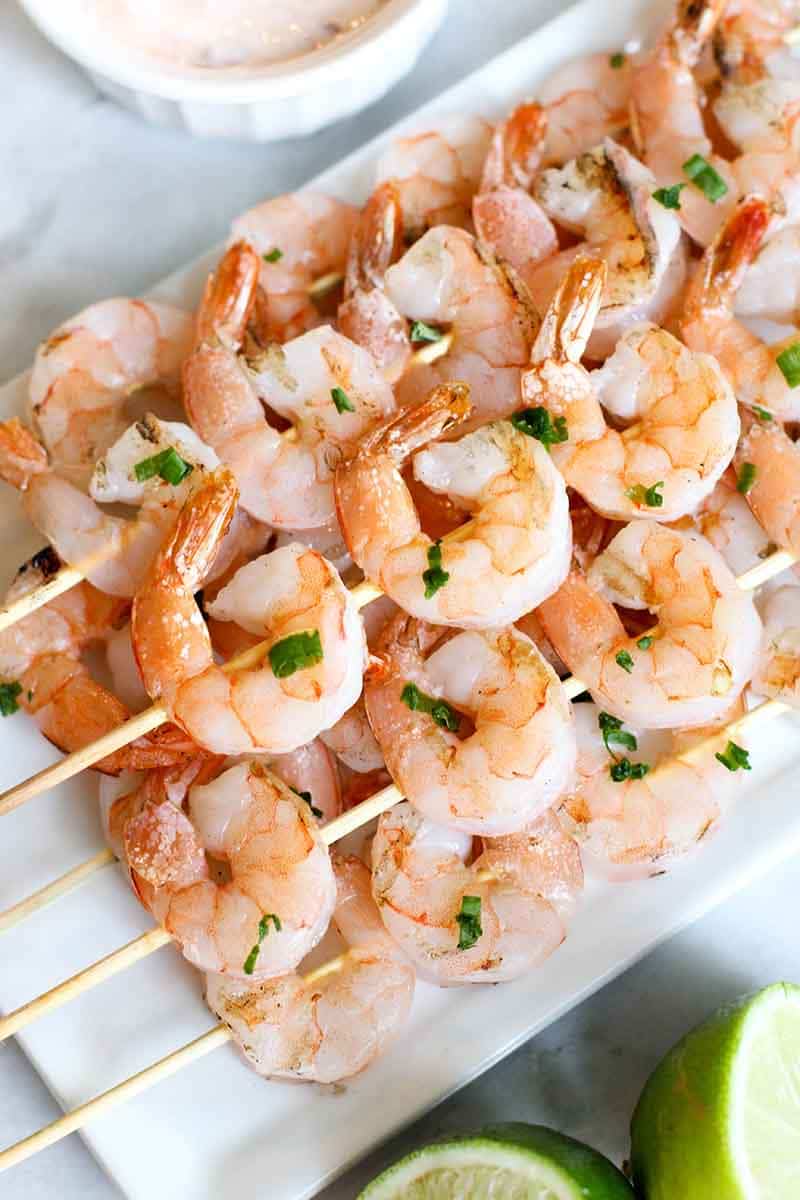 Stack of Grilled Shrimp Skewers on a white plate