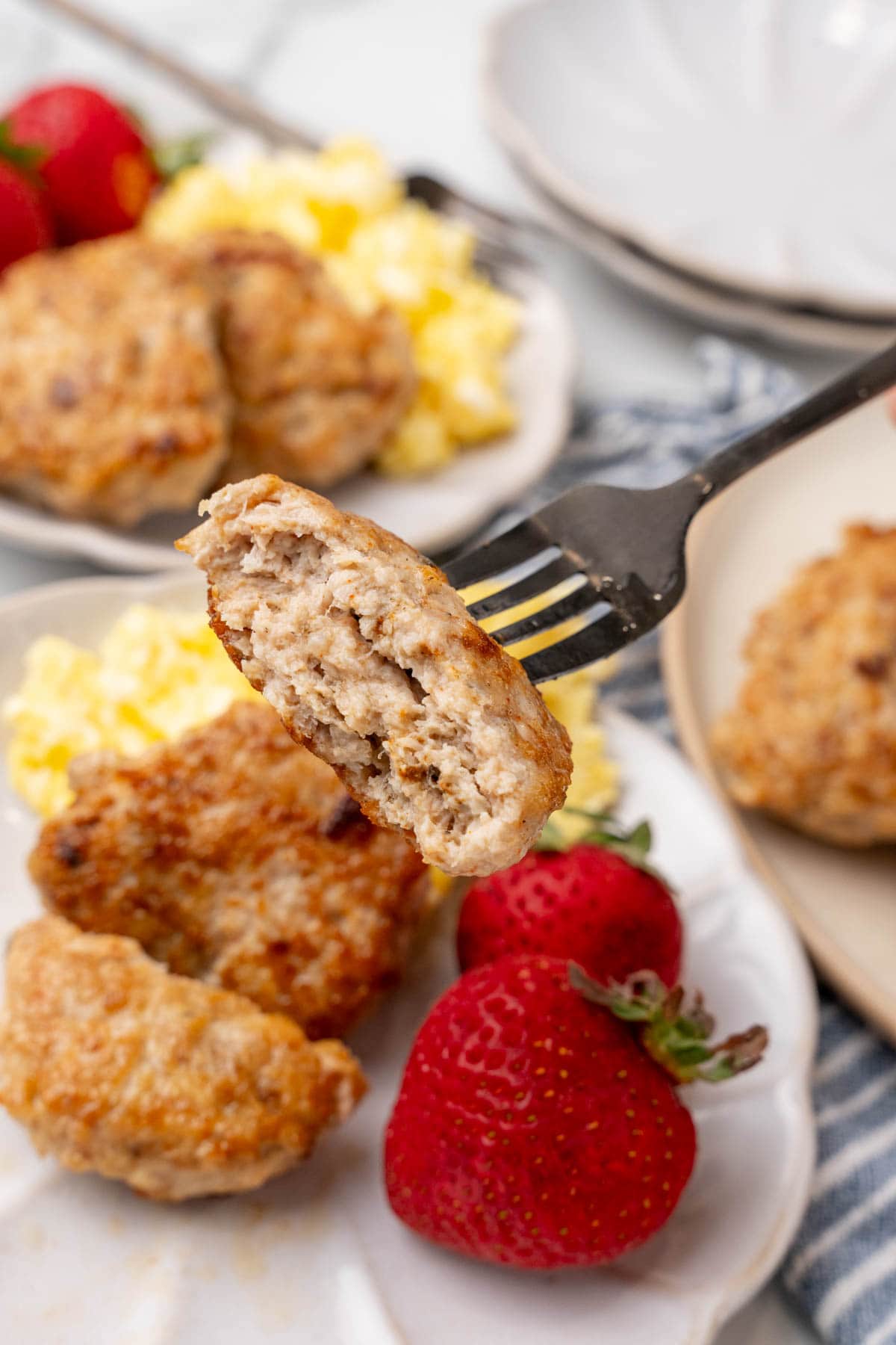 Fork holding half a breakfast sausage 