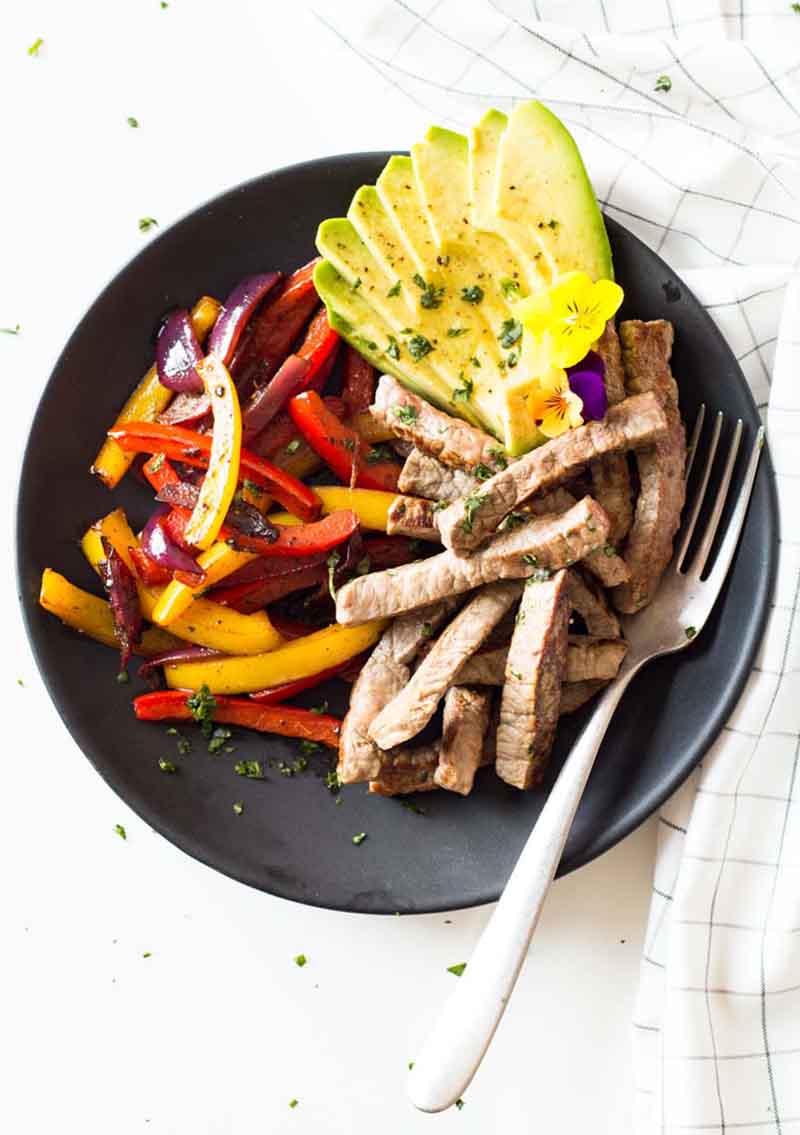 Overhead shot of the cooked beef, veggies, and avocado on a plate