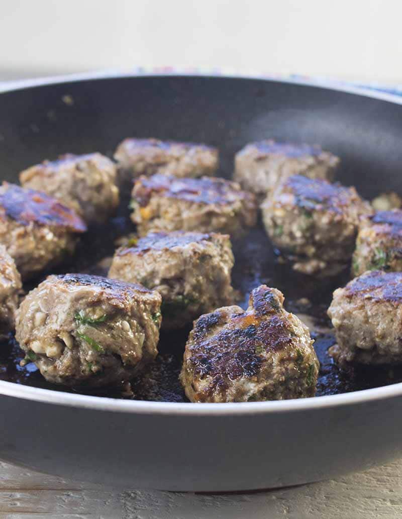 Meatballs cooking in a skillet