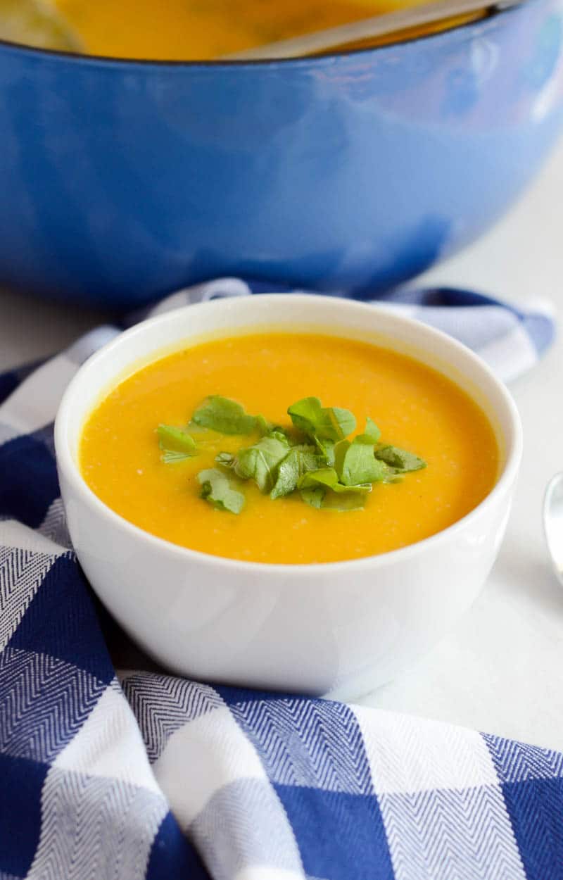 Creamy Kabocha Squash and Cauliflower Soup in a small bowl with garnish on top