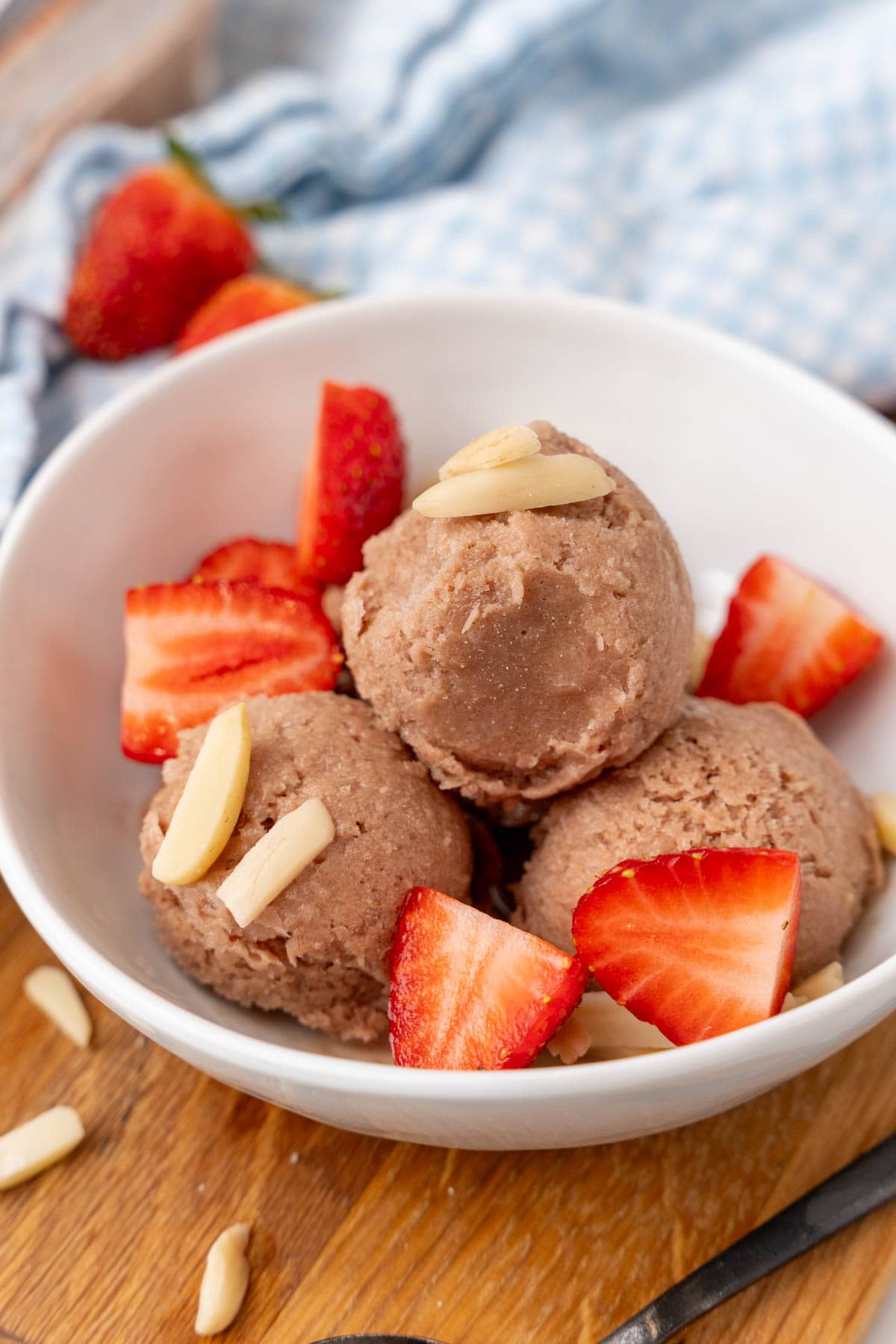 Chocolate Greek Yogurt Ice Cream in a bowls, topped with slivered almonds and strawberries