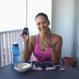 Christel holding a blood sugar meter while eating lunch on the balcony