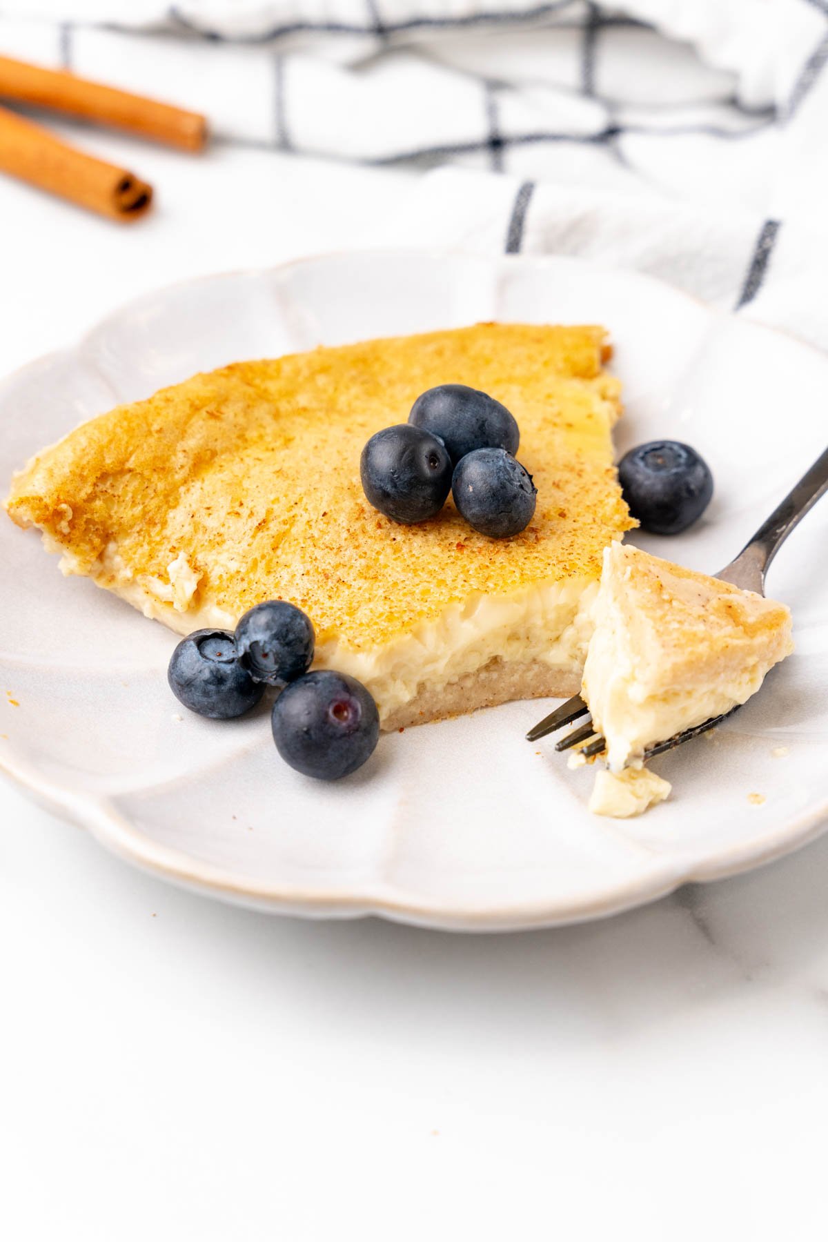 Fork cutting a bite out of a slice of custard pie