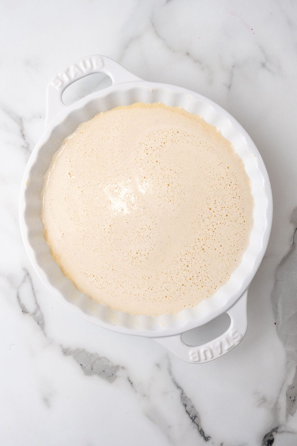 Custard mixture in a pie pan before baking