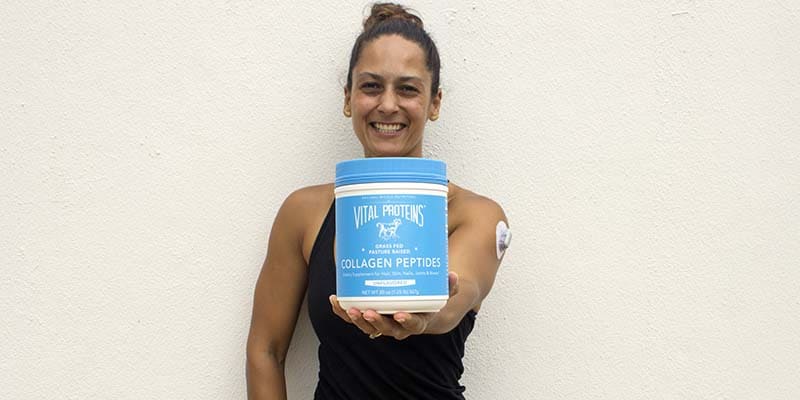 Christel holding a can of collagen protein