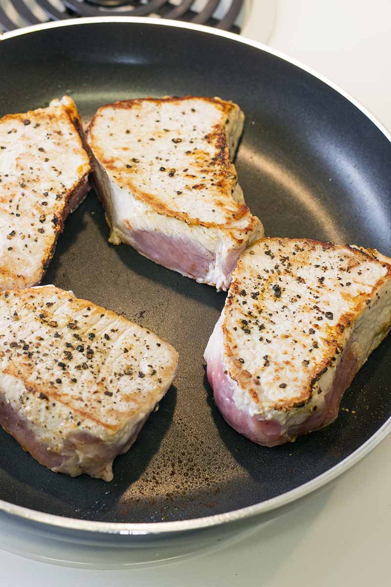Searing the pork chops in a pan