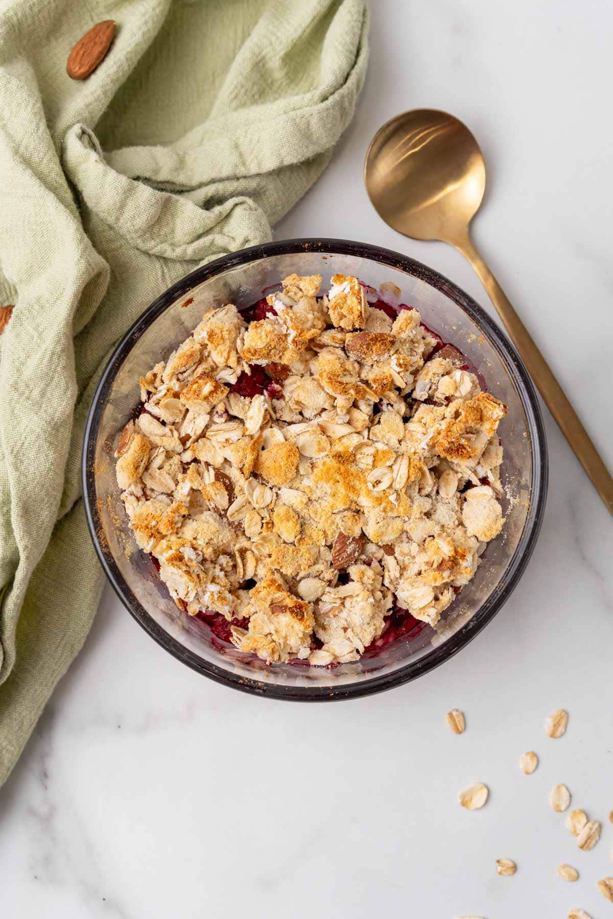 Finished high protein berry crumble on table with spoon