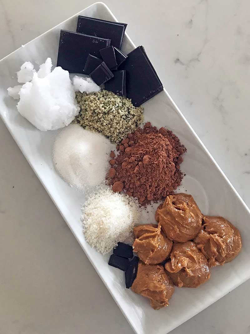 All the raw ingredients for chocolate keto fat bombs on a plate