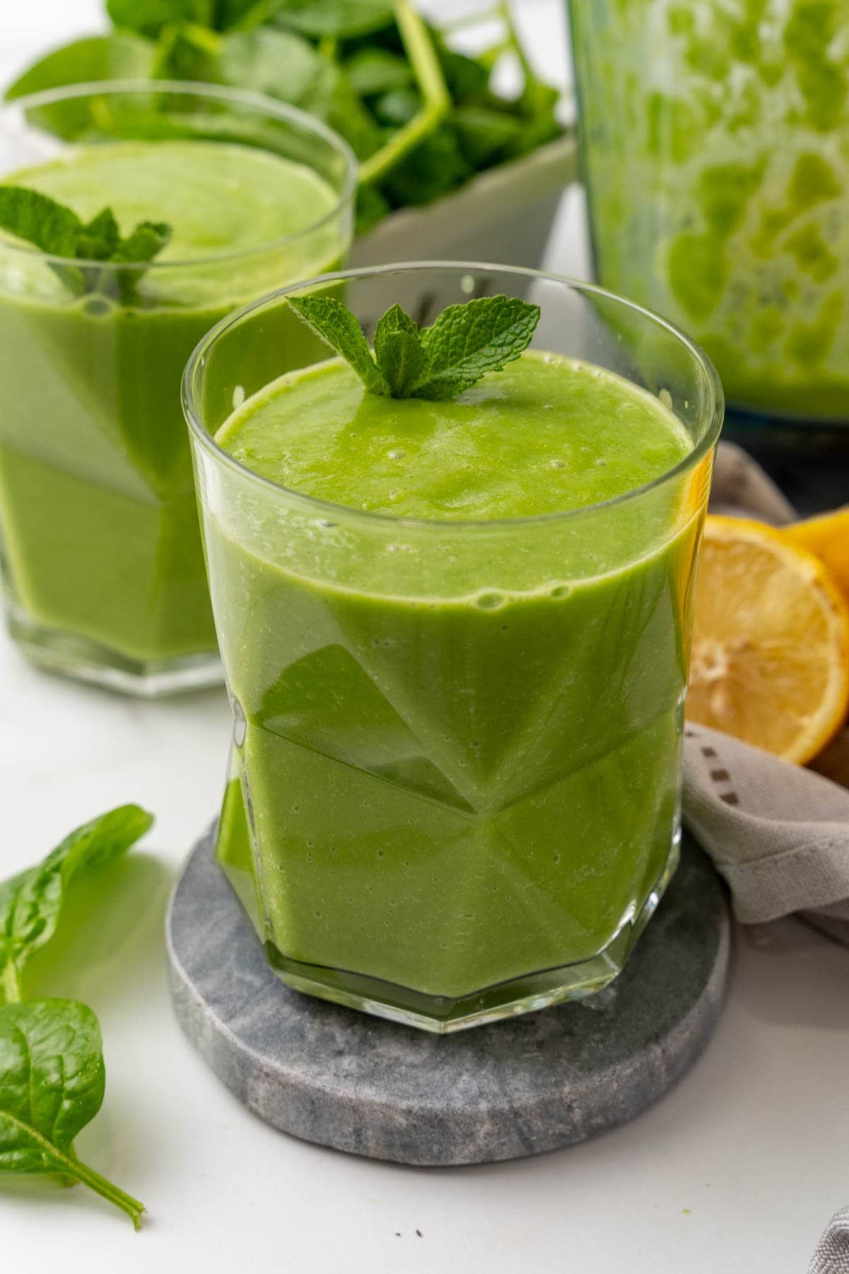 Two glasses of avocado smoothie garnished with mint leaves