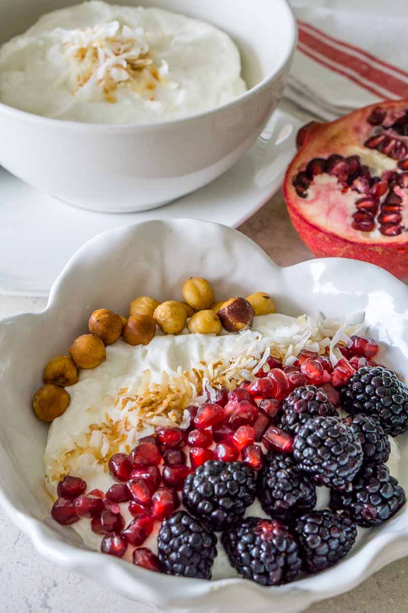 Whipped Cottage Cheese Breakfast Bowl topped with berries, coconut flakes, and hazelnuts