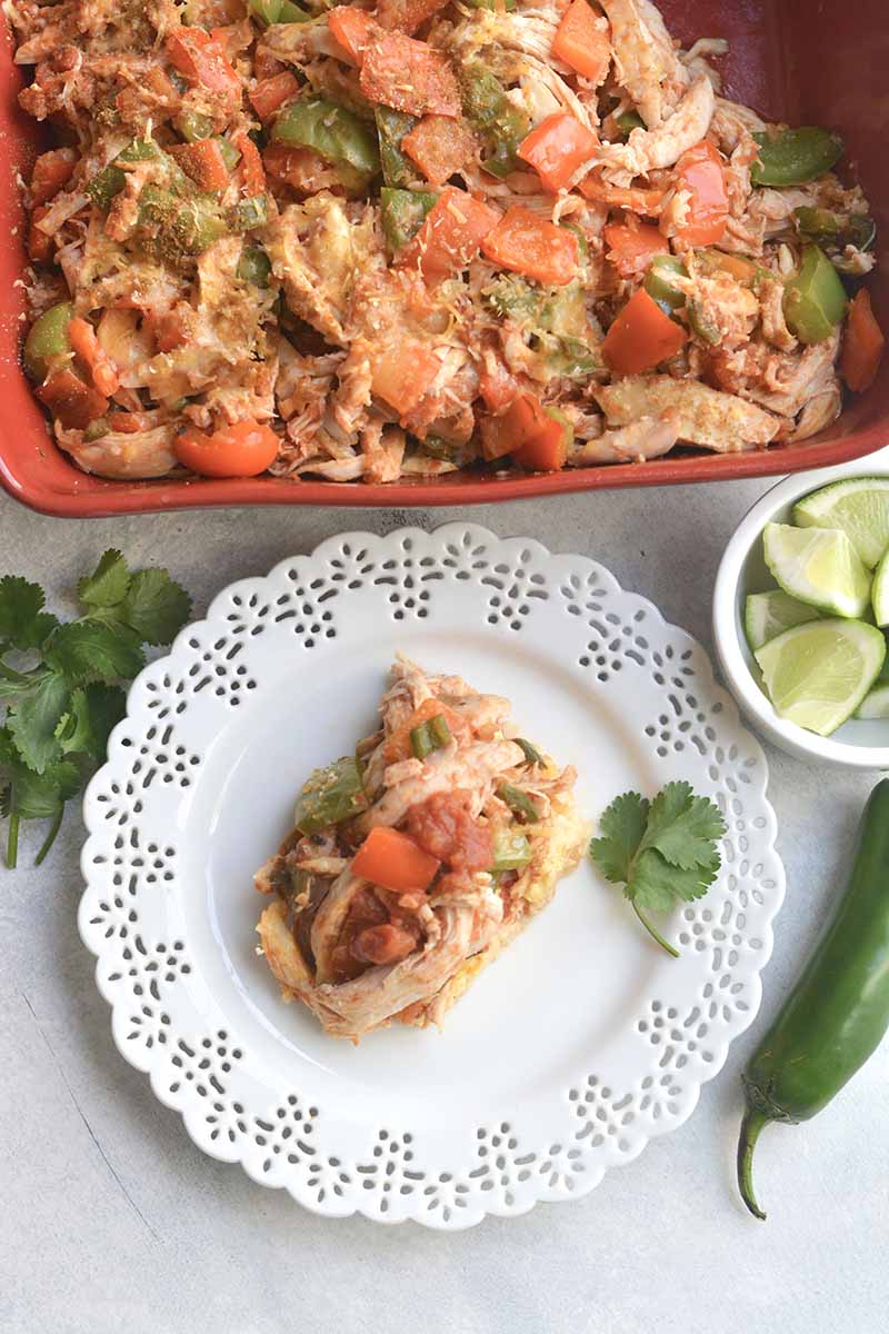 Serving of low-carb casserole on a white plate in front of baking dish 