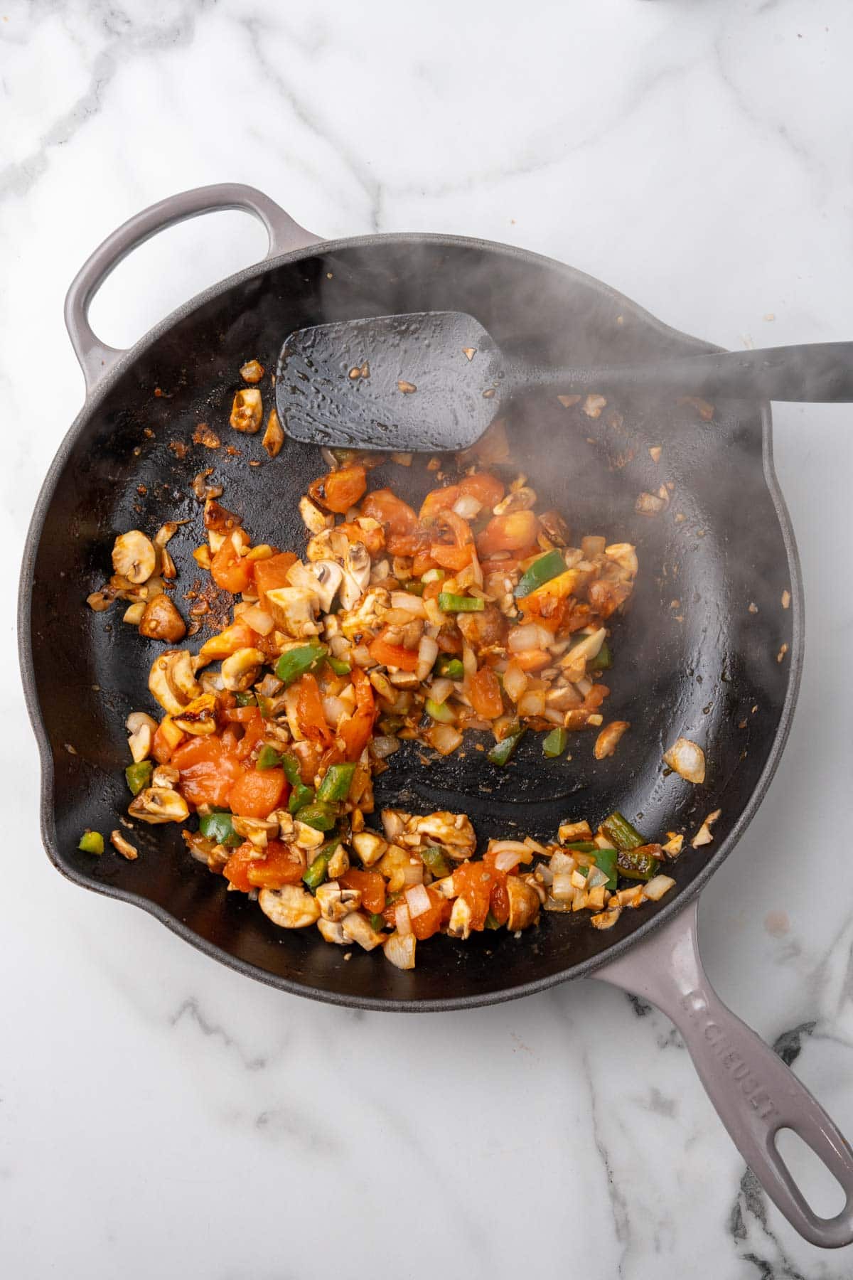 Vegetables sautéing in a cast-iron pan