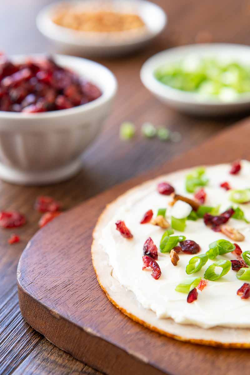 turkey slice with cranberries, pecans and green onions on a cutting board