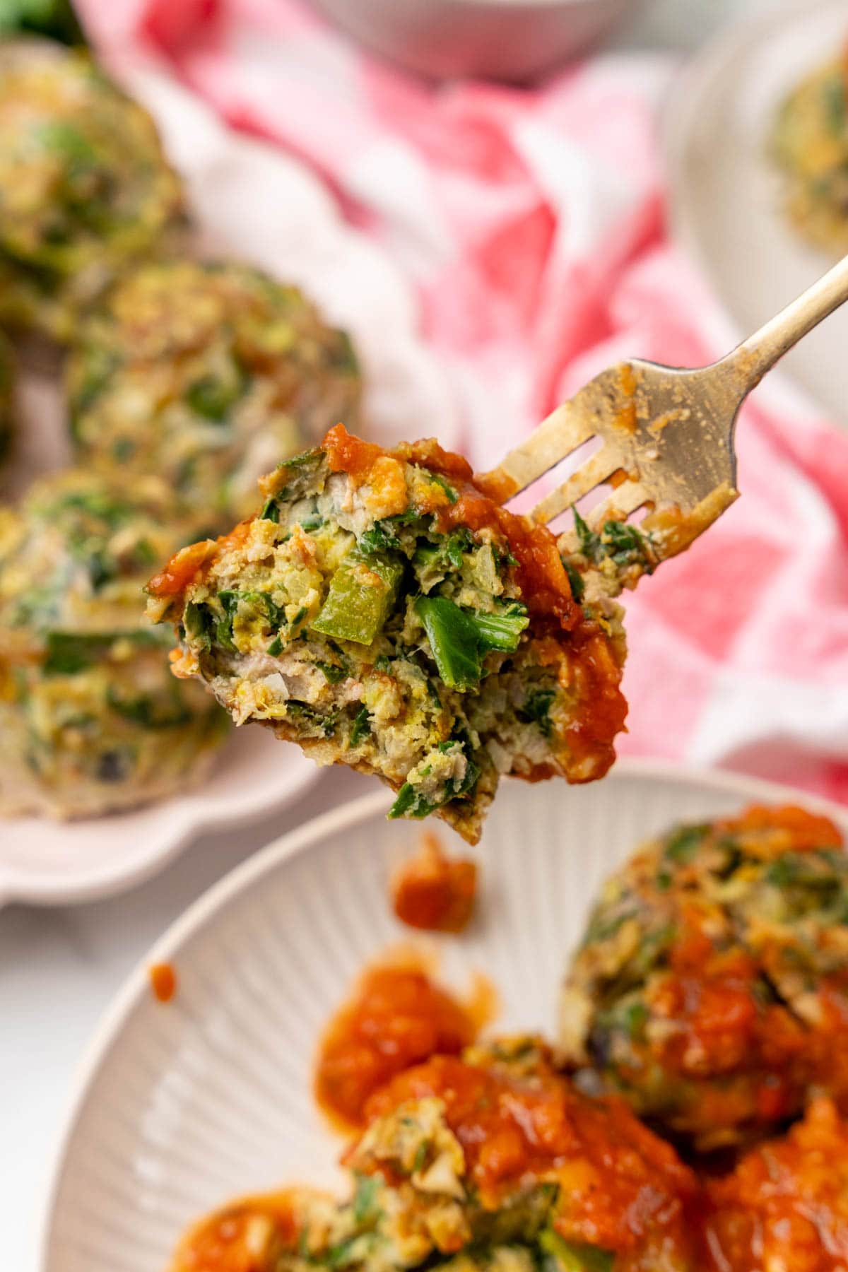 Fork holding a turkey meatball with tomato sauce