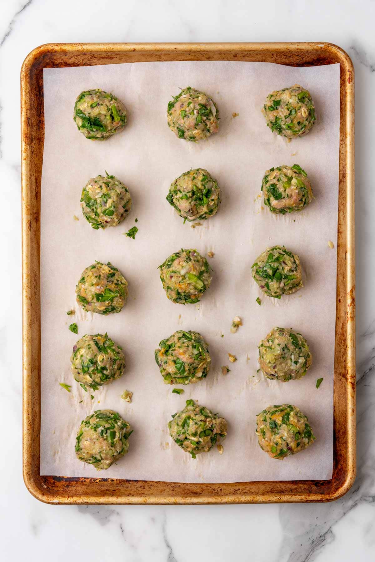 Baking sheet with 15 turkey meatballs ready to go in the oven