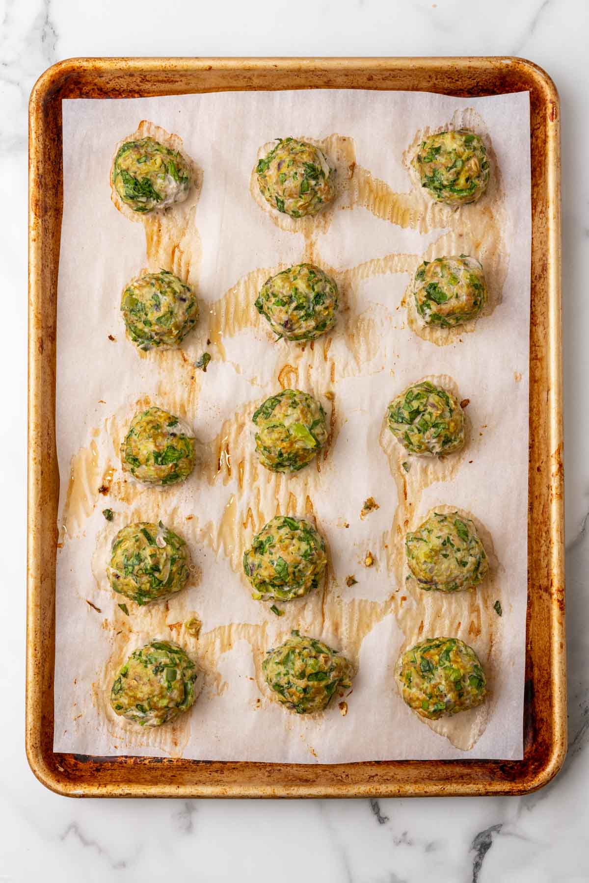 Turkey meatballs on a baking sheet coming out of the oven