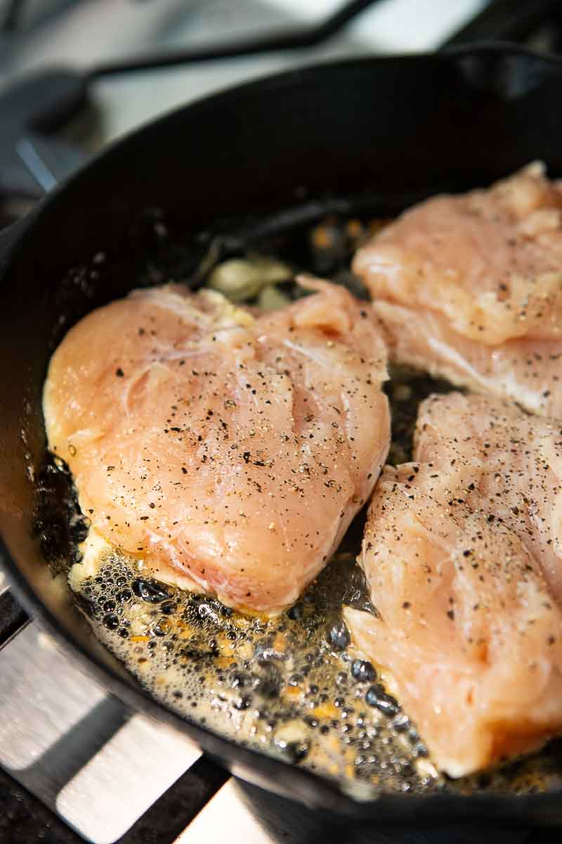 sauteeing chicken breasts in a skillet