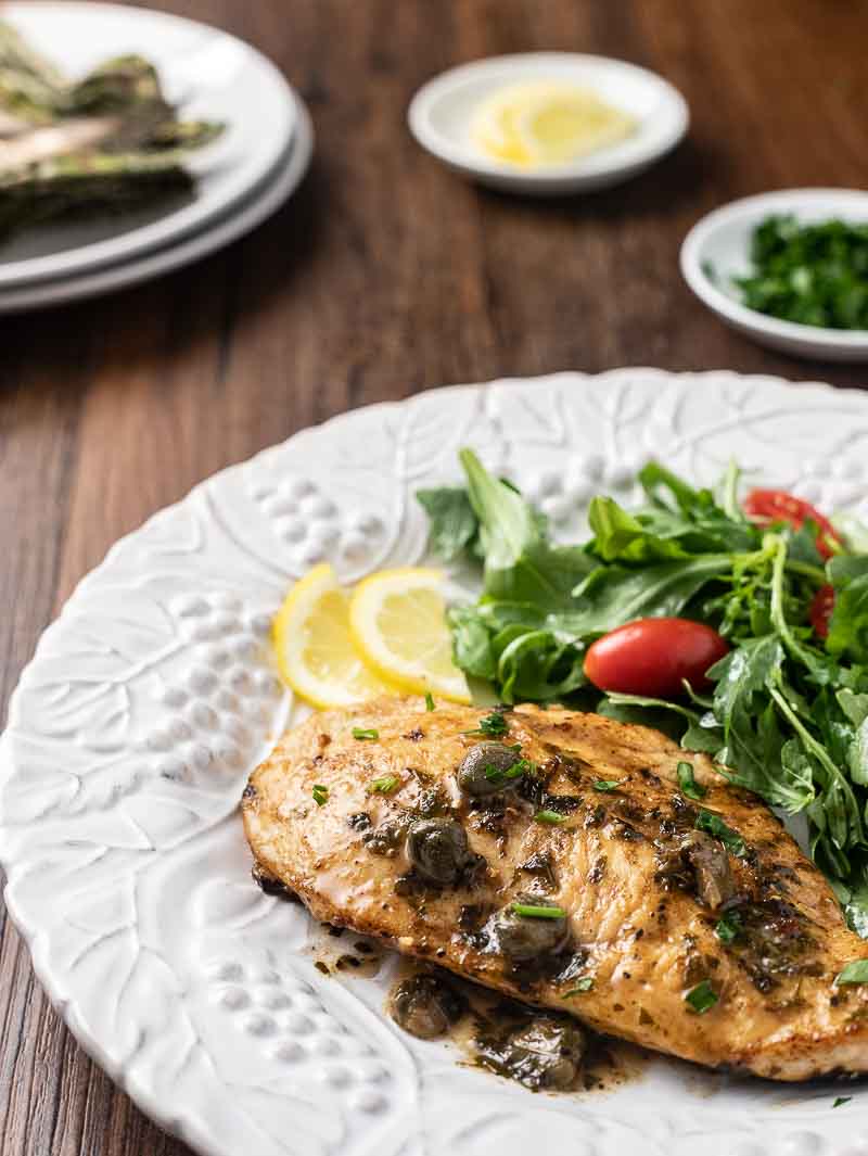 Plate with Lemon Piccata Chicken and side salad. 