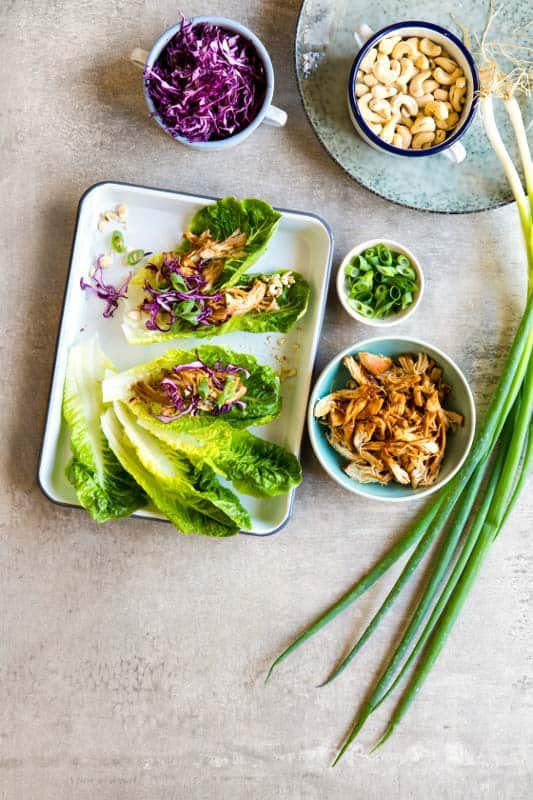 Hoisin Chicken Lettuce Wraps on a tray next to ramekins of individual ingredients, as seen from above