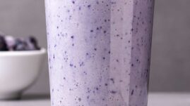 Glass of blueberry smoothie with straw
