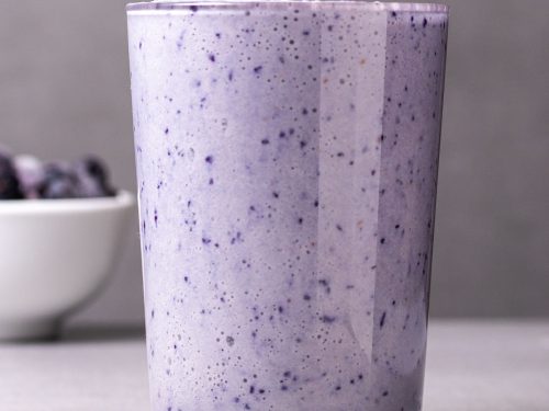 Glass of blueberry smoothie with straw