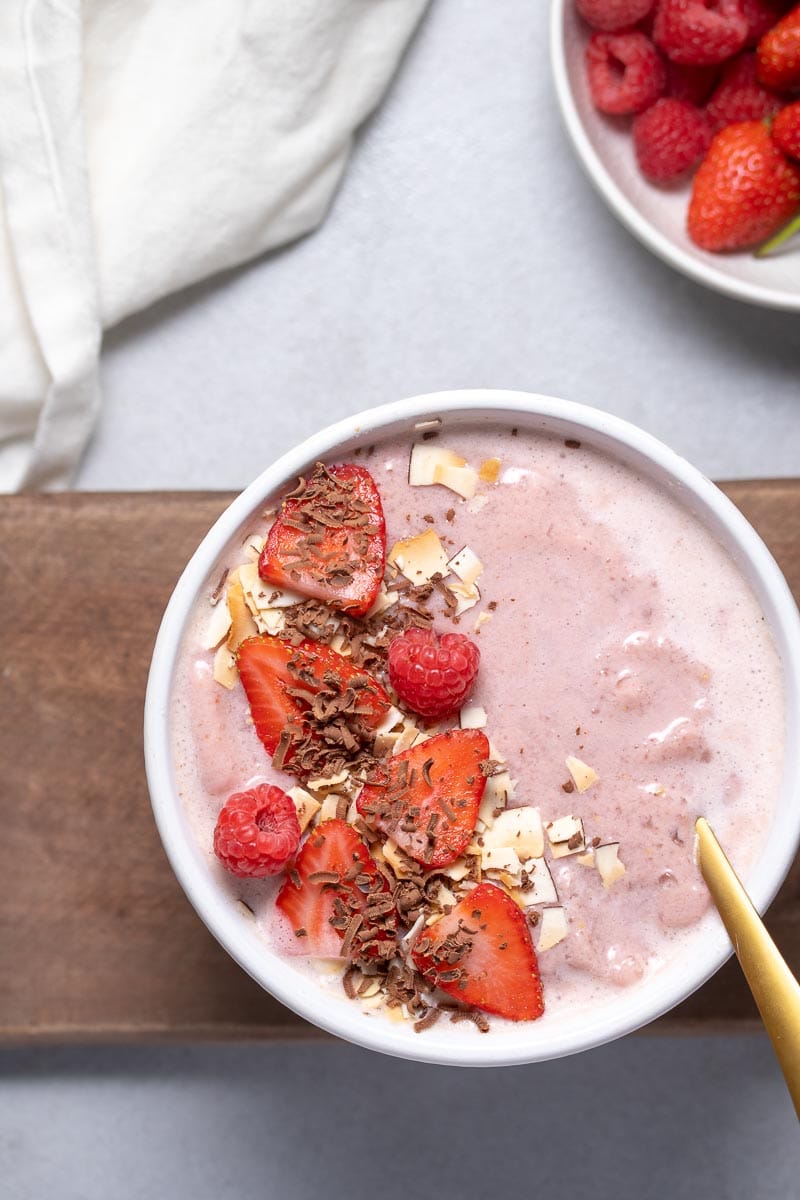 Garnished smoothie bowl with a gold spoon as seen from above