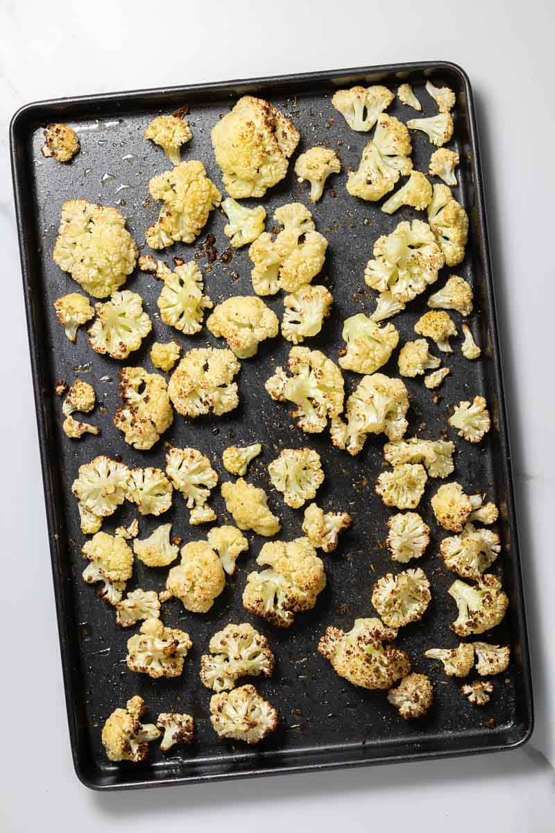 Roasted cauliflower florets on a baking tray 