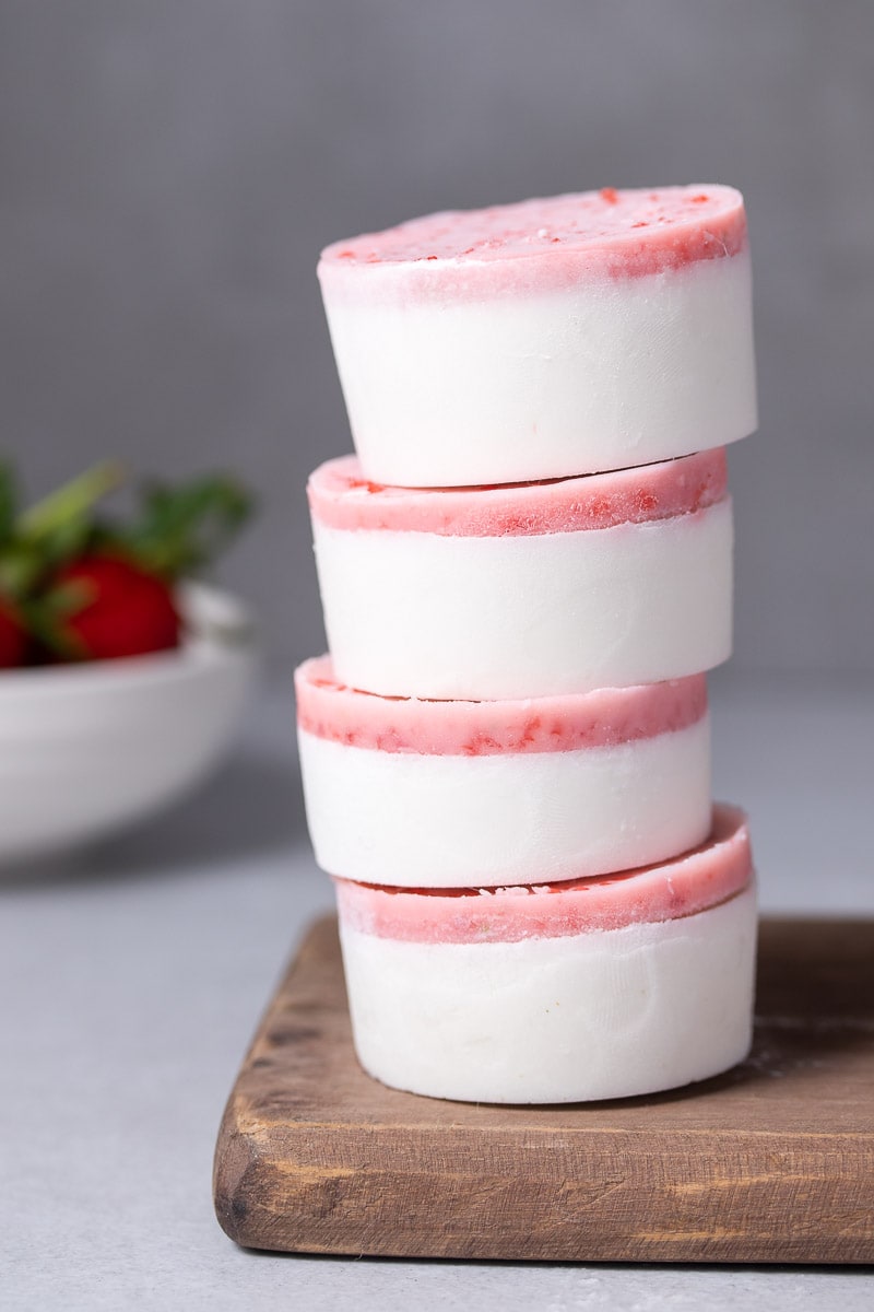 Stack of four fat bombs with strawberries in the background