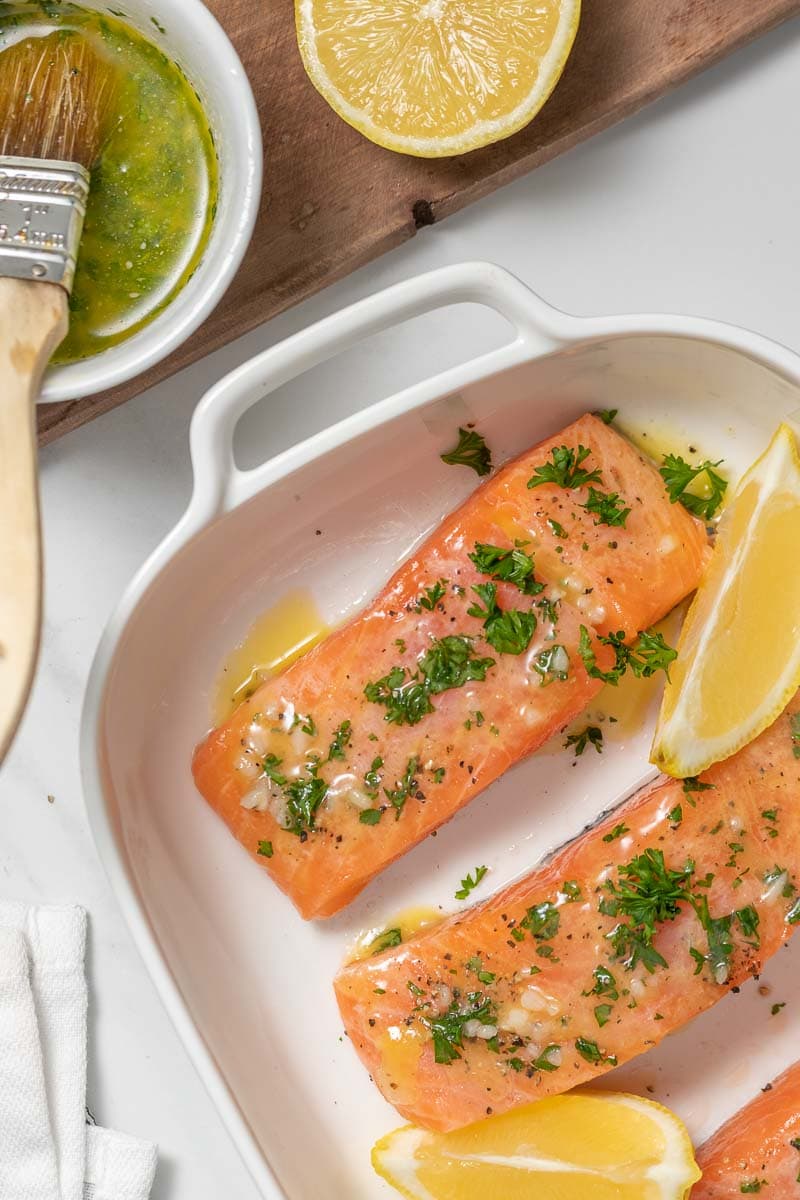 Raw salmon steaks brushed with butter, lemon, and garlic