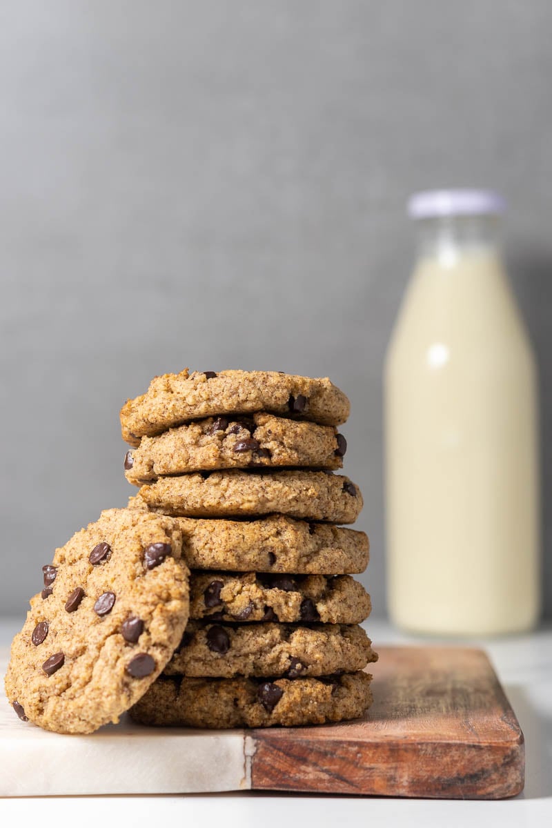 Stack of Sugar-free Chocolate Chip Cookies on a cutting board with a jar of milk in the background