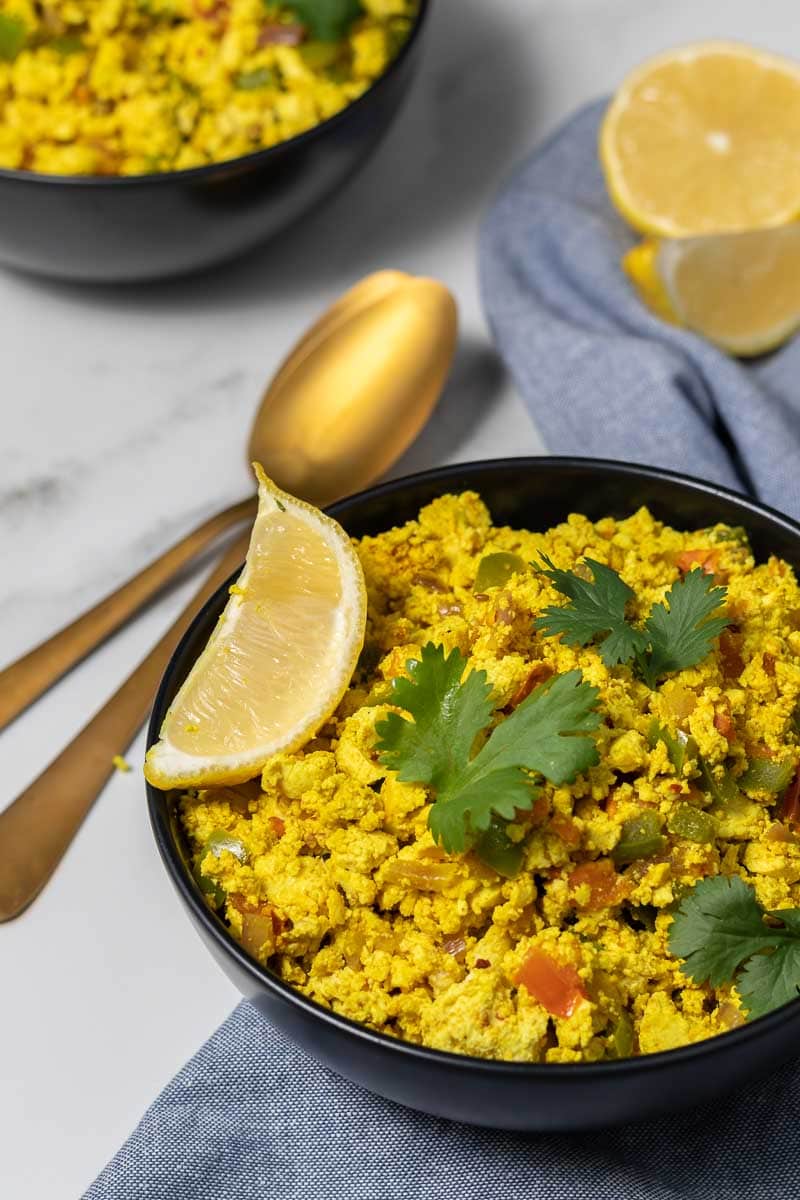 Simple Tofu Scramble Recipe served in a bowl and garnished with cilantro and a lemon wedge