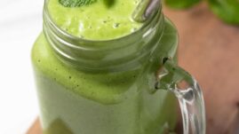 Glass of green keto smoothie with straw