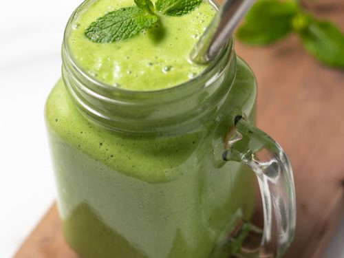 Glass of green keto smoothie with straw