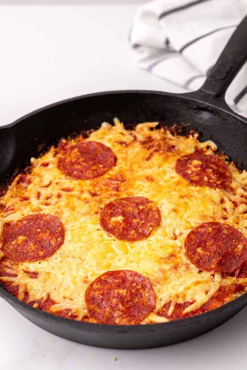 Baked pizza casserole in a cast iron skillet, ready to be served