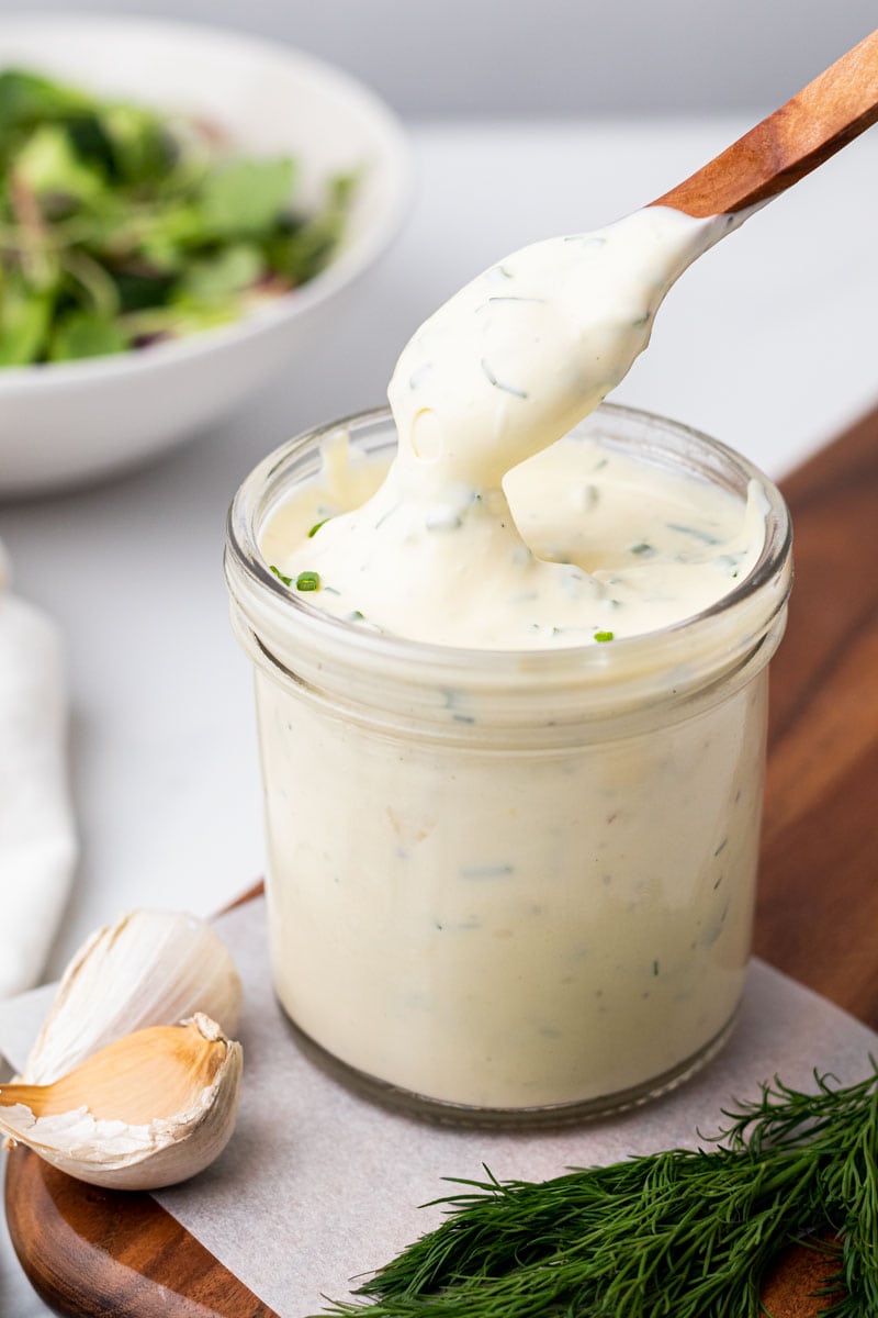 Wooden spoon scooping out some ranch from a glass jar