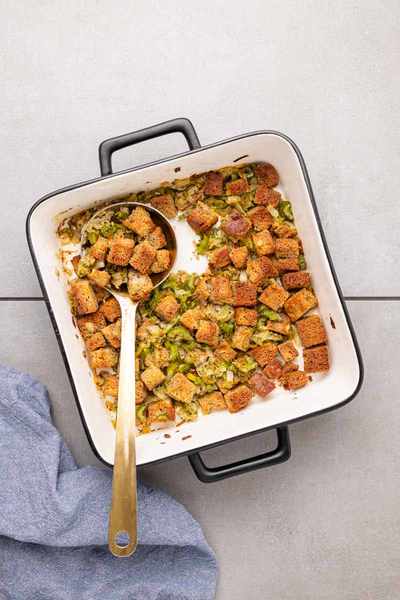 Low carb stuffing in a baking dish with a spoon scooping out a serving