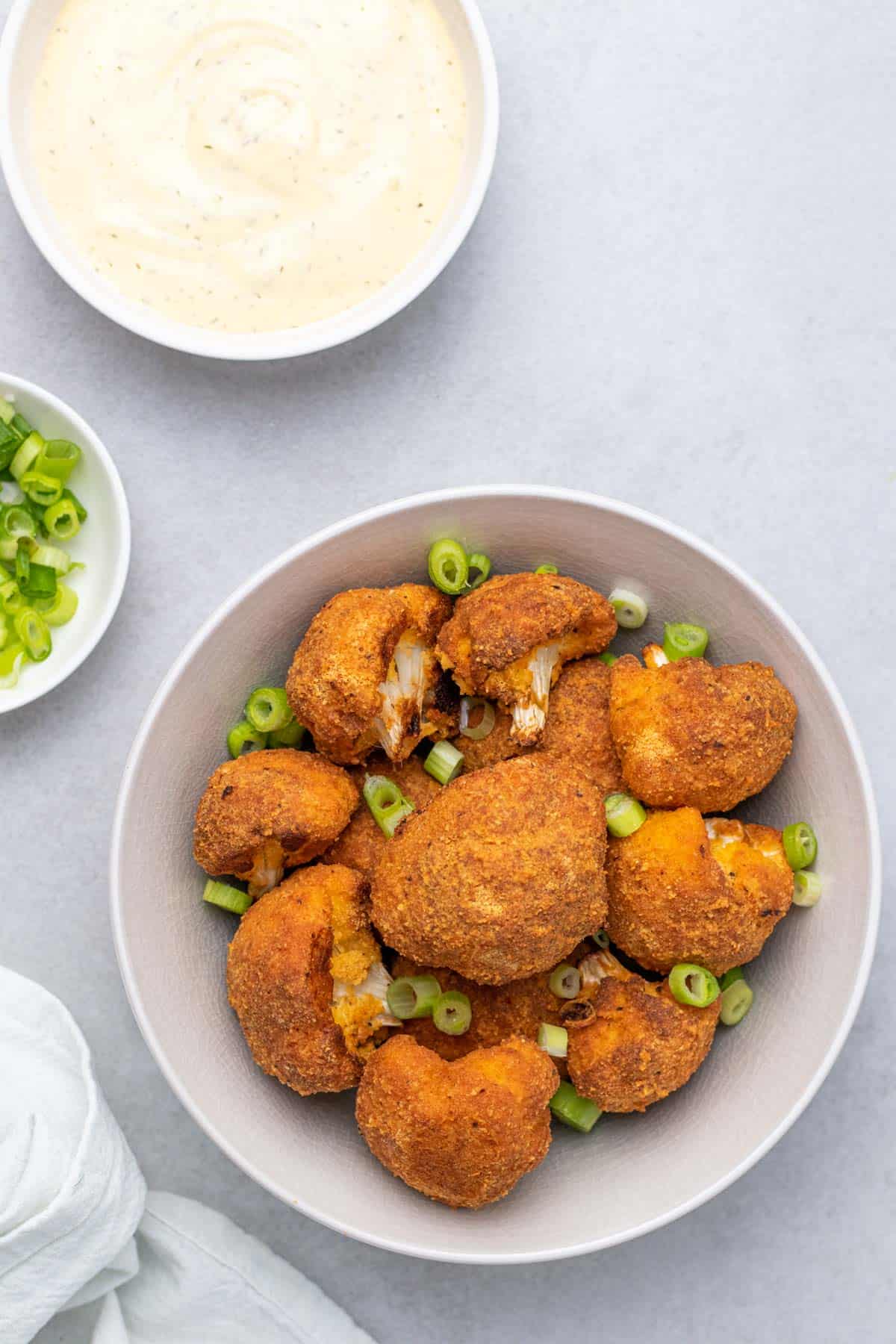 cauliflower wings garnished with green onion in bowl