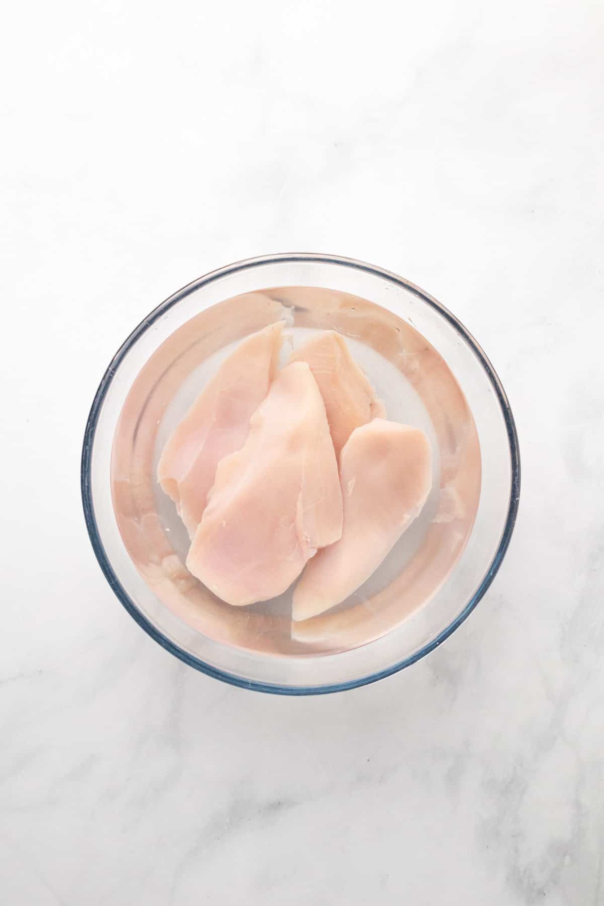 chicken breasts soaking in large bowl
