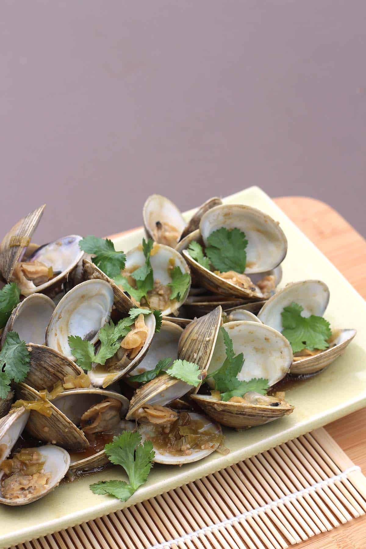 Asian Steamed Clams with Ginger and Garlic on a platter garnished with cilantro